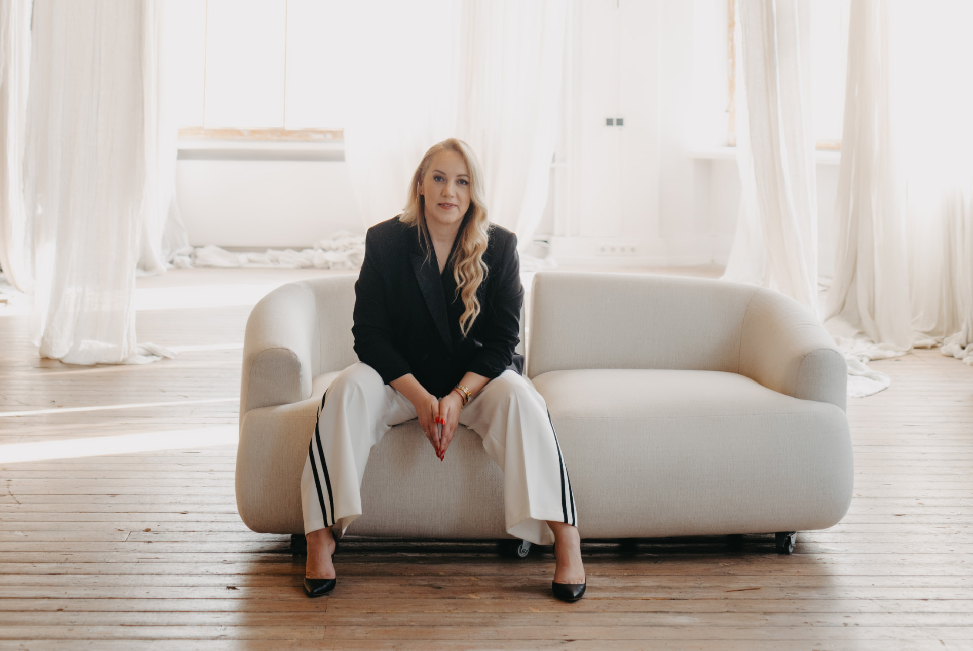 Ieva Lībķena sēž krēslā gaišā telpā